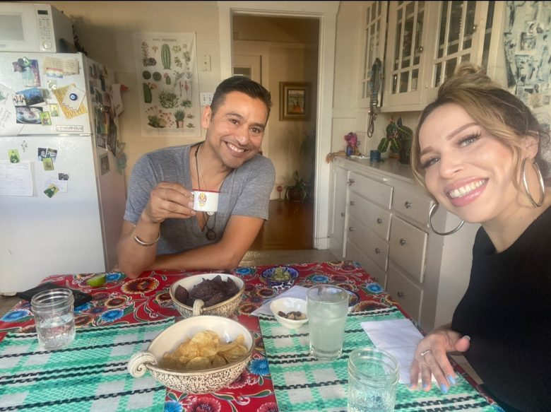 Alberto Rangel and Katherine Alvarez sitting at a table with snacks.