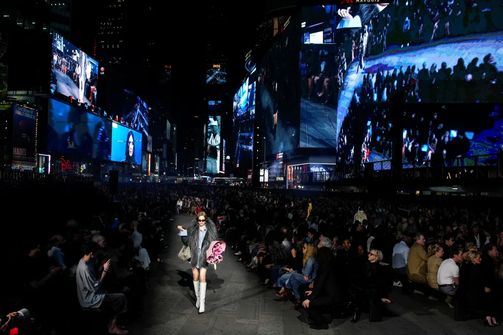 A model presents a Gucci Cruise 2027 collection creation at Times Square.