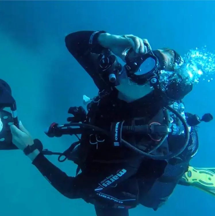 Scuba diver taking a photo underwater.