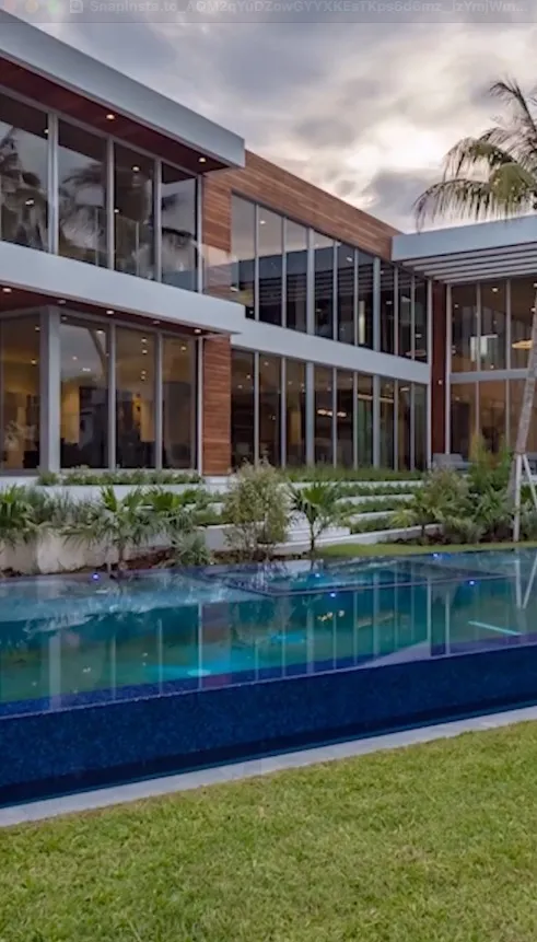 Exterior of a modern house with a pool and landscaped garden.