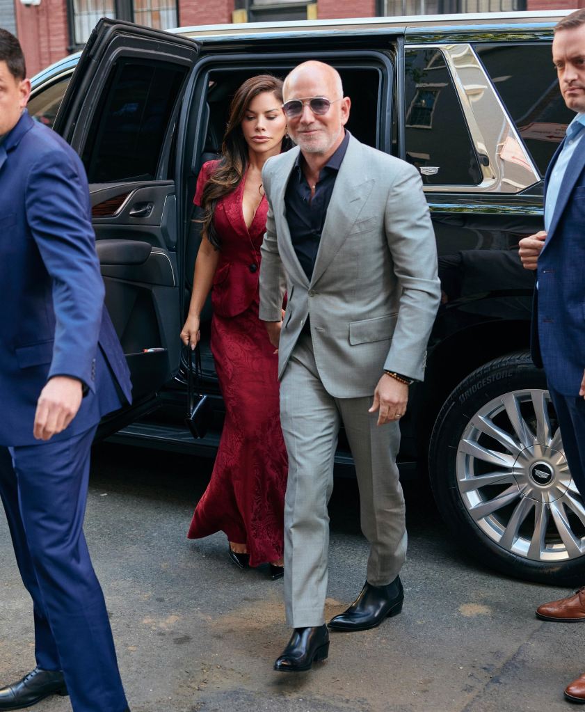Jeff Bezos in a gray suit and Lauren Sanchez in a red dress arriving at the Met Gala dinner.