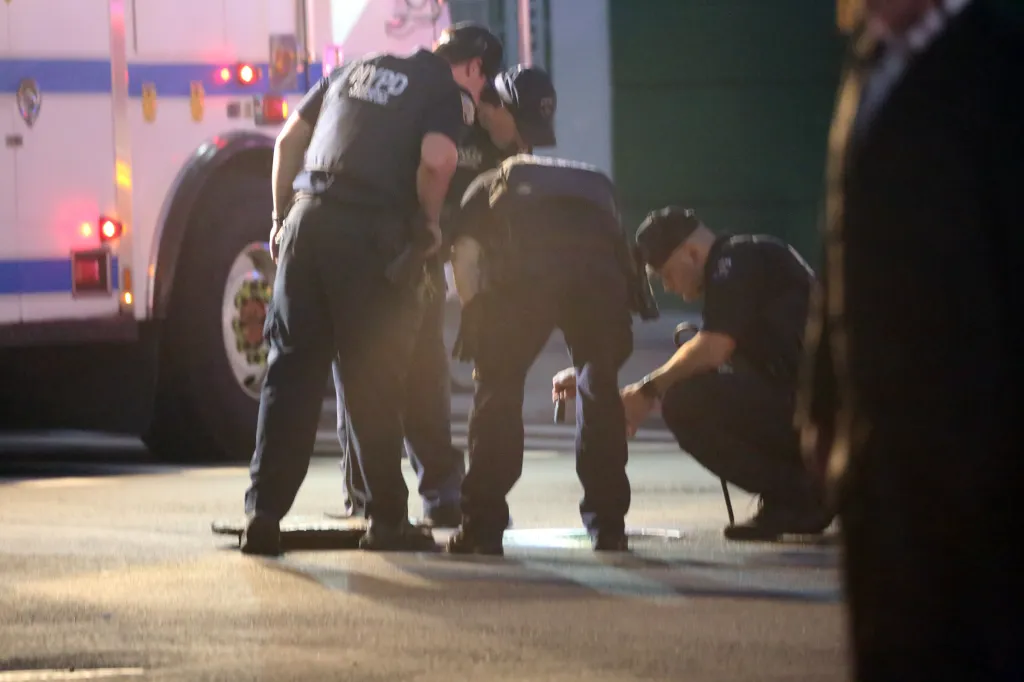 New York City Police Emergency Service personnel examining a manhole.