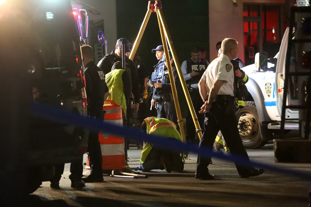 New York City Police Emergency Service personnel examining a manhole.