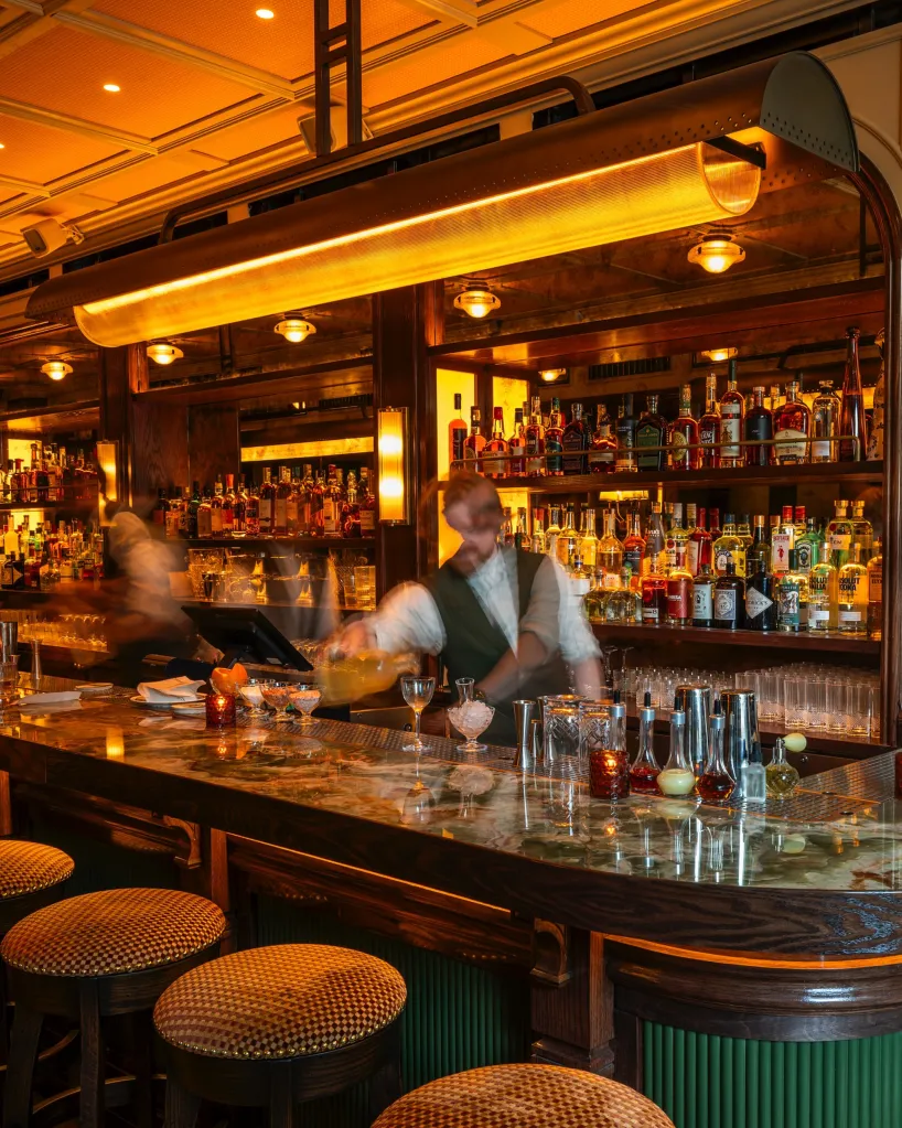 A bartender at a hot spot Corner Store bar, making a drink.