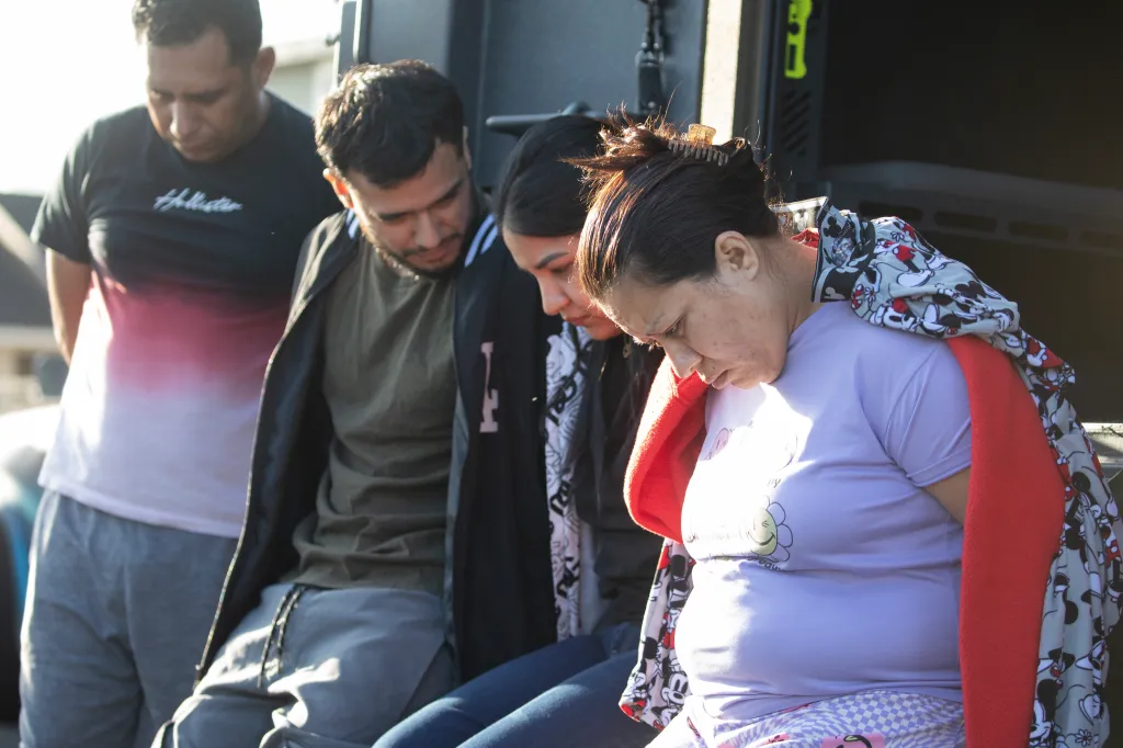 Four suspects, including Karen Orelana-Garcia and Malally Moreno-Lopez, are seated with their heads down during a drug raid.