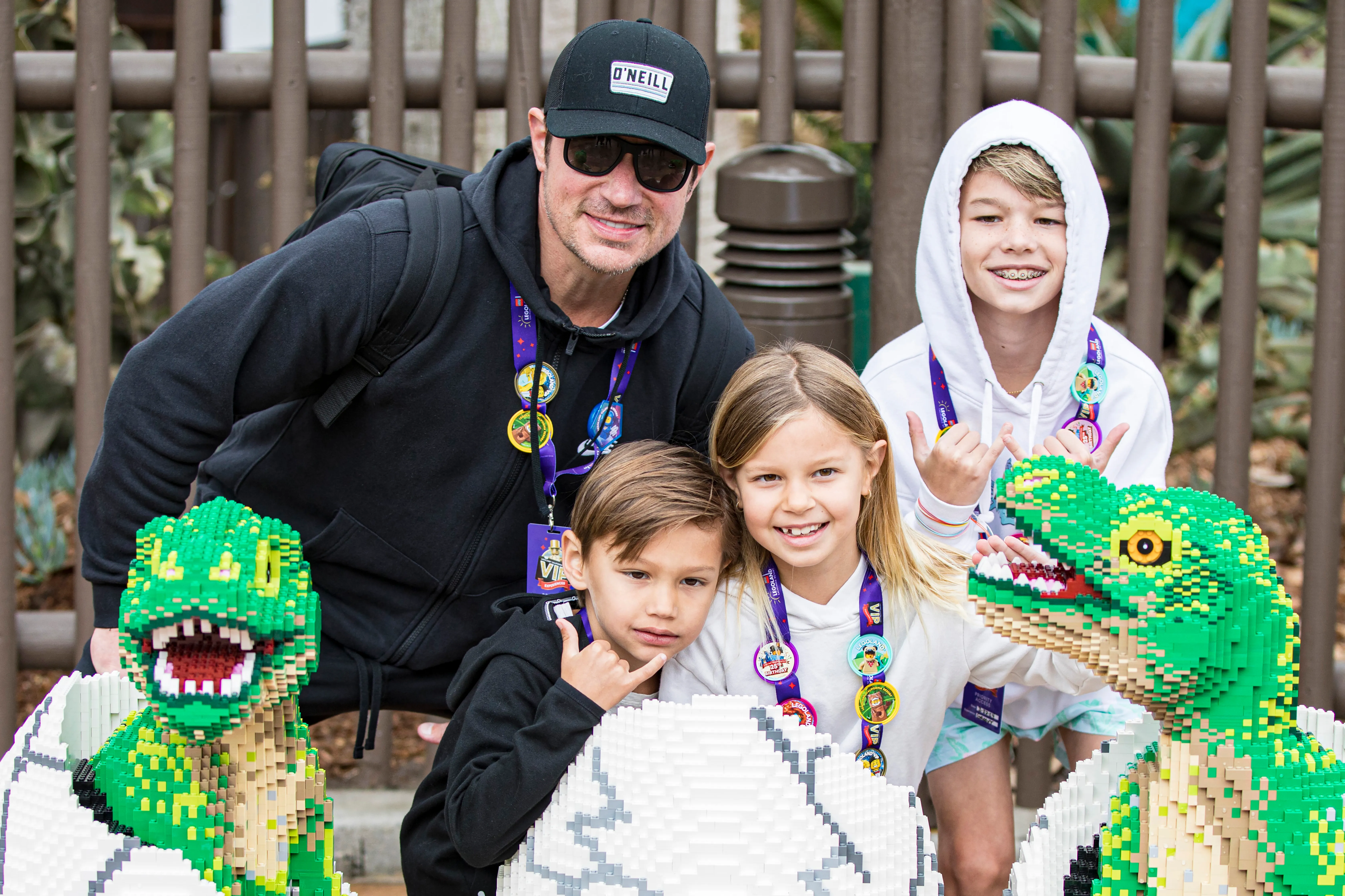 Nick Lachey, with children Phoenix, Brooklyn, and Camden, poses with Lego dinosaurs at the LEGOLAND California Dino Valley Grand Opening.