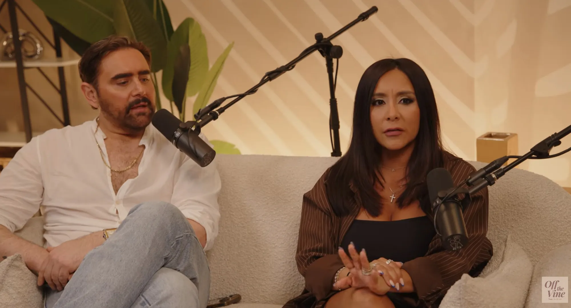 Nicole 'Snooki' Polizzi and a man sit on a couch for a podcast interview.