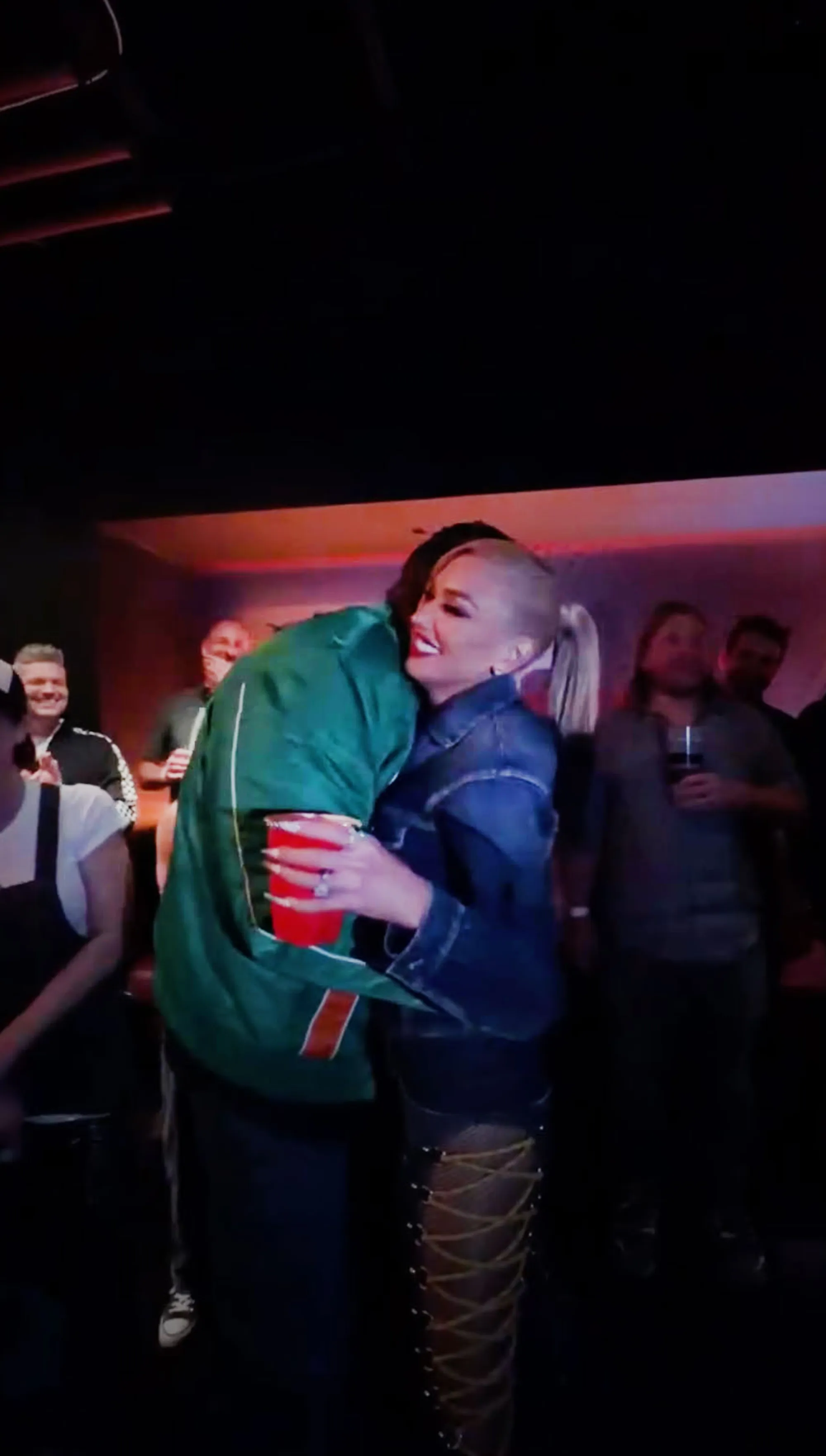Gwen Stefani embracing Blake Shelton in a dark club.