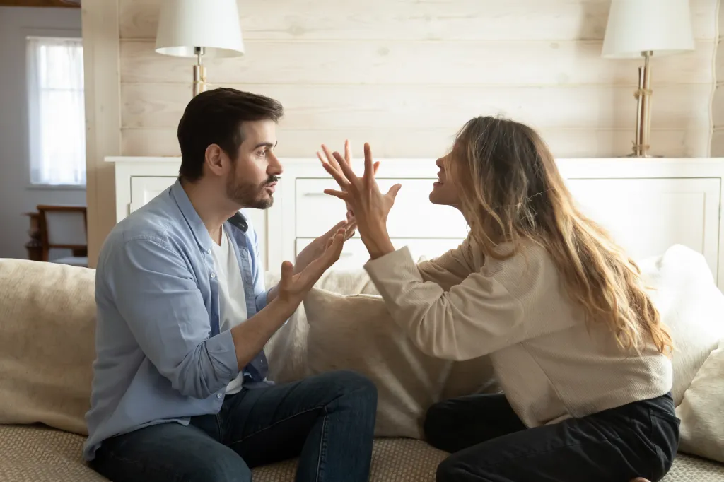 A couple arguing, a man talking to a woman who is gesturing emphatically with her hands.