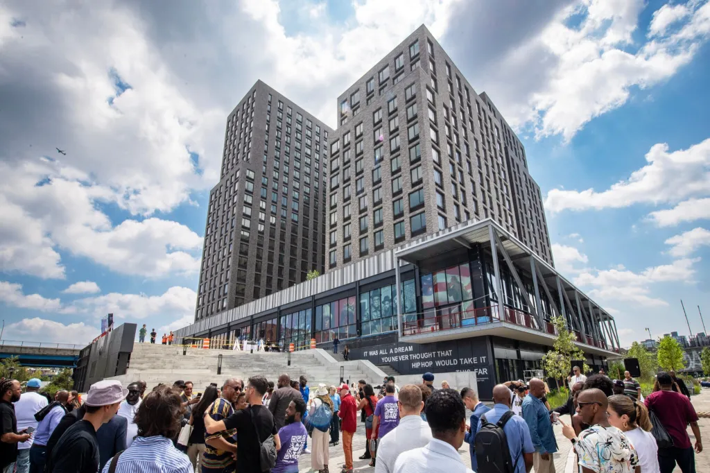 Exterior of the Hip Hop Museum in the Bronx, New York, with a crowd gathered in front.