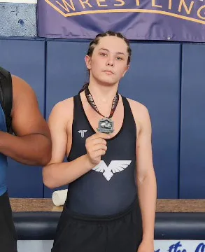 Former high school wrestler Cain Clark holding a medal.
