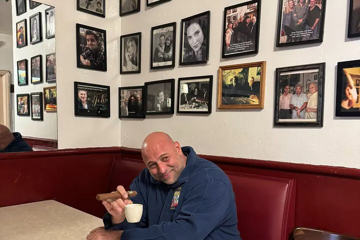 Retired NYPD Detective Luis holding a cigar and a cup.