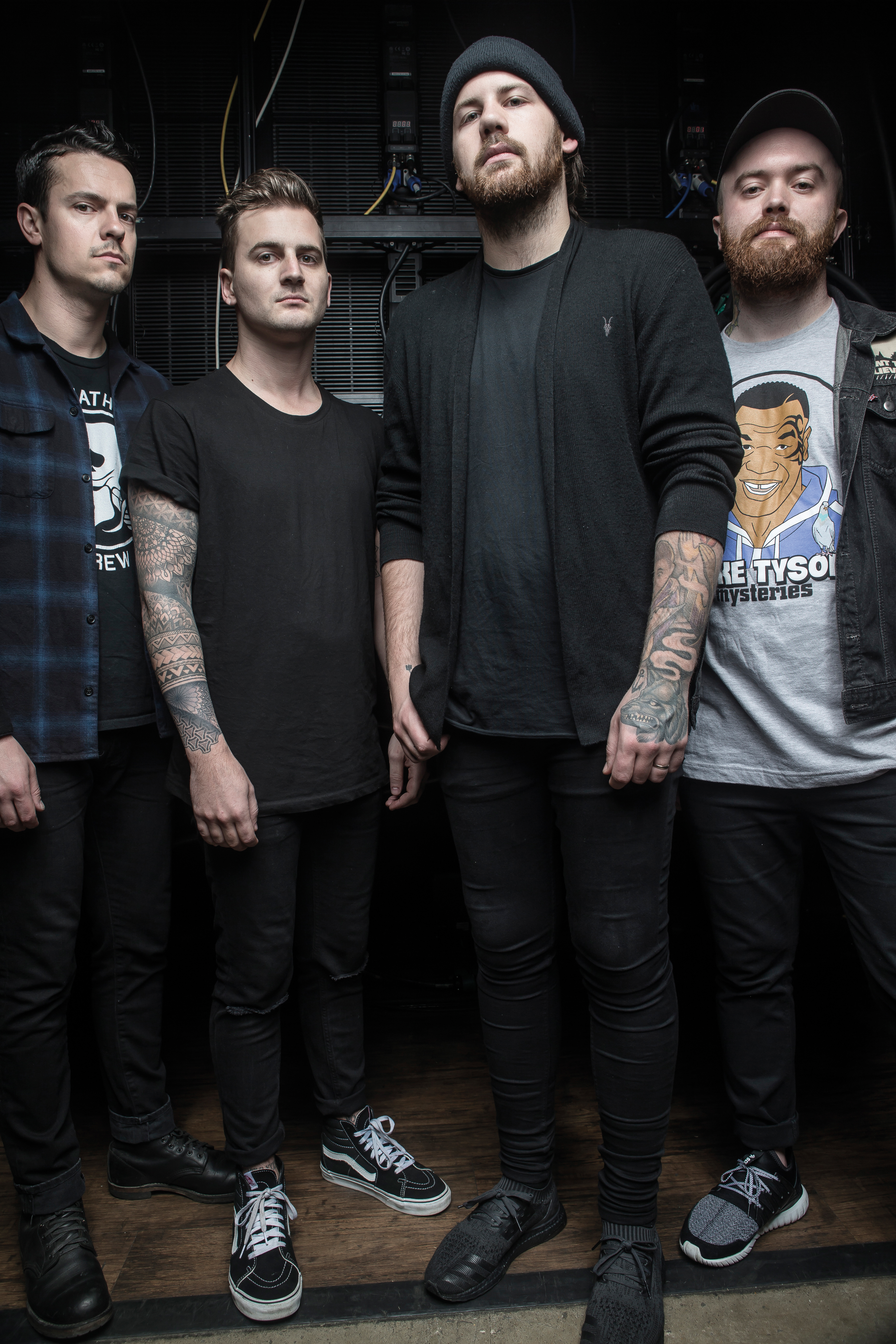 Portrait of Beartooth band members Oshie Bichar, Kamron Bradbury, Caleb Shomo, and Taylor Lumley posing indoors.
