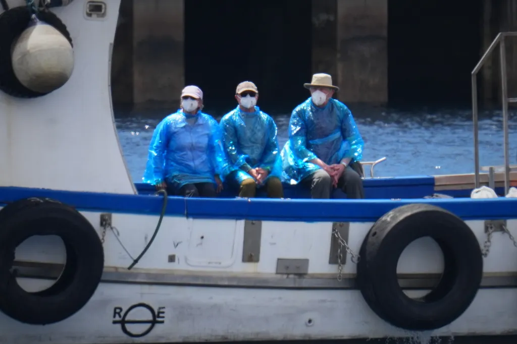 Passengers disembarking from a hantavirus-stricken cruise ship wearing protective gear.
