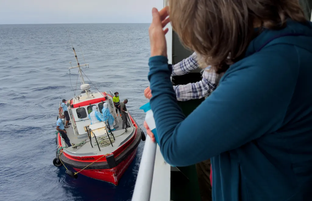 Passengers watching epidemiologists board the Hantavirus-stricken cruise ship.