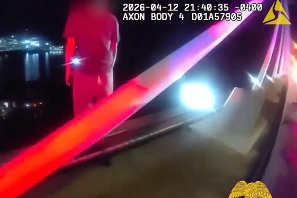 Bodycam footage of a man standing on the edge of a bridge at night, with flashing police lights.