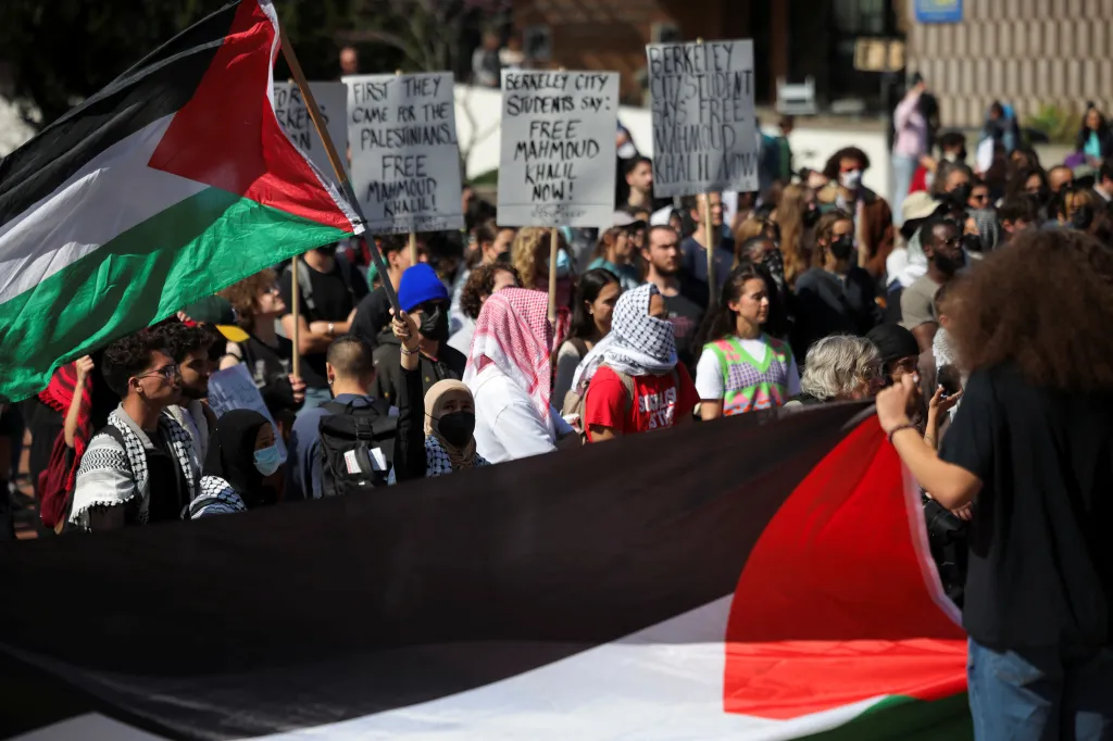 People at a protest in Berkeley, California, hold a Palestinian flag and signs calling for the release of Mahmoud Khalil.