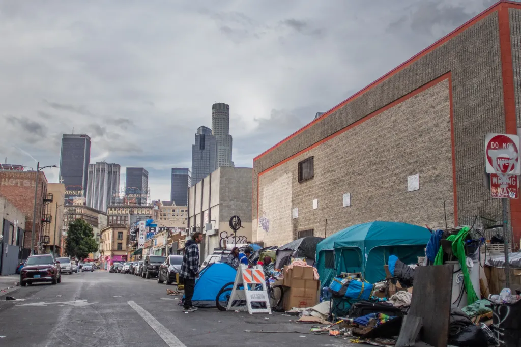 People gather outside tents on the street in Skid Row in Los Angeles, California.