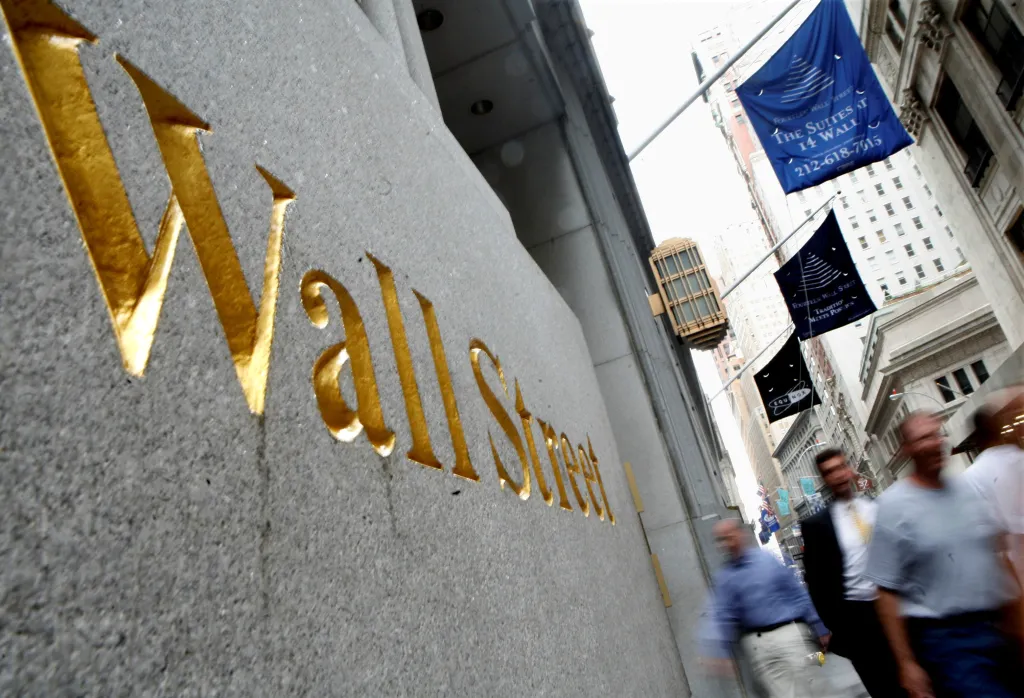 People walk past the gold lettering of 