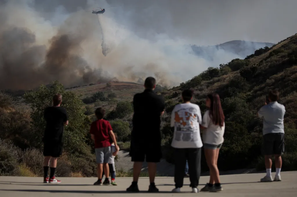 People watch as a helicopter battles the Sandy Fire in Simi Valley, California.