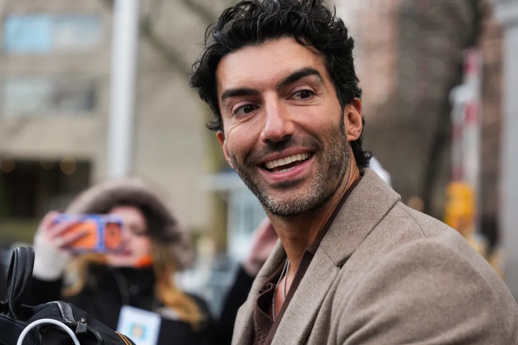 Justin Baldoni smiling at court.
