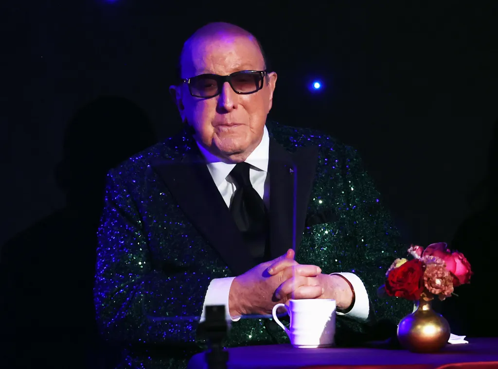 Clive Davis on stage in a sparkly green tuxedo and dark sunglasses at the Pre-GRAMMY Gala & GRAMMY Salute to Industry Icons.