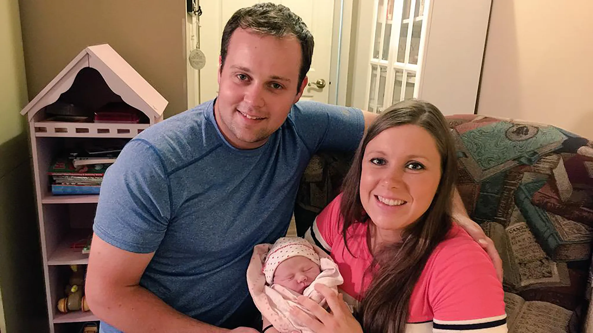 Josh and Anna Duggar holding their newborn baby.