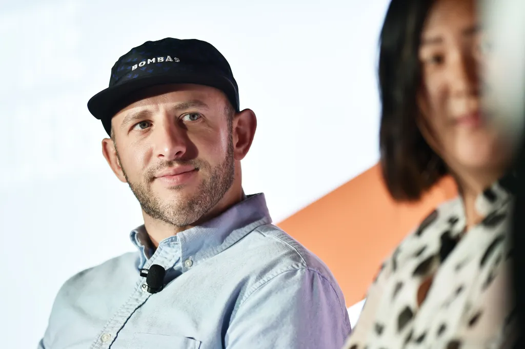 David Heath, CEO of Bombas, in a cap and light blue shirt.