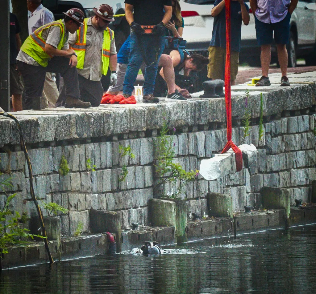 A piece of the Christopher Columbus statue is pulled from the harbor in Baltimore.