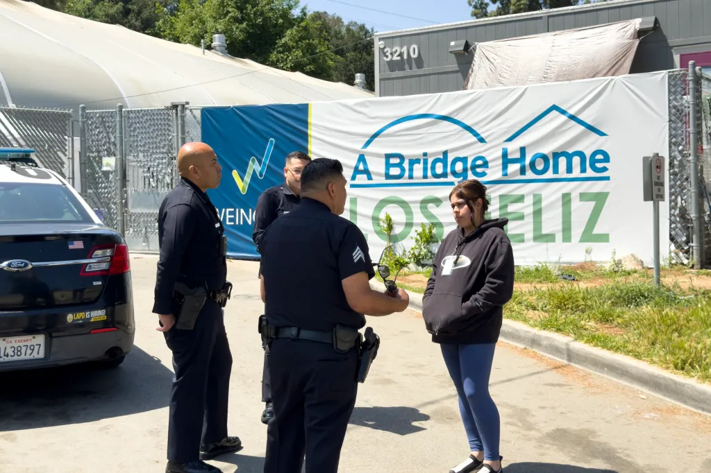 Police officers interacting with a woman outside 