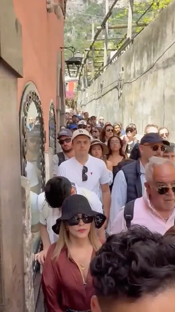 A crowded alleyway in Positano, Italy, filled with tourists.