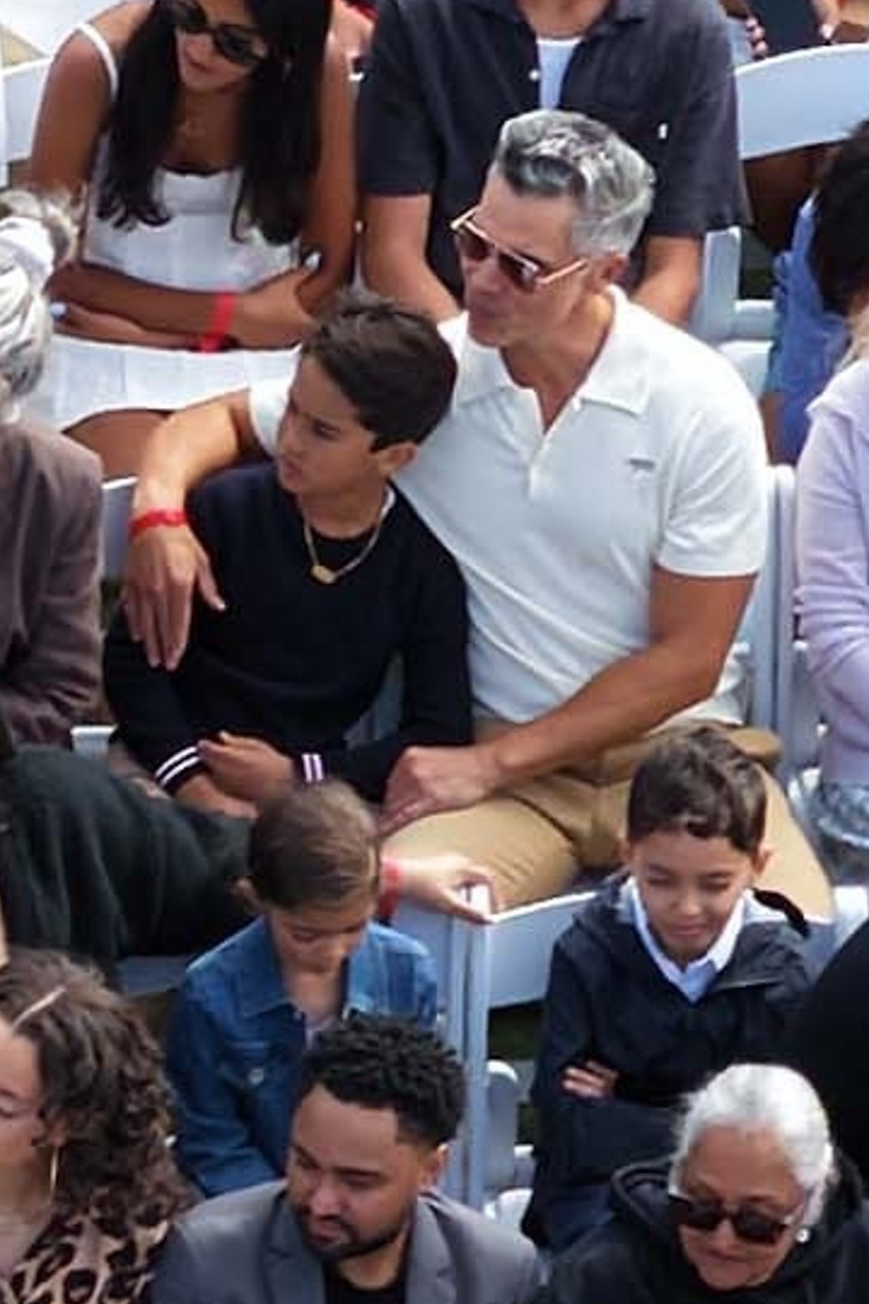 Cash Warren sitting with his son Hayes at a graduation ceremony.
