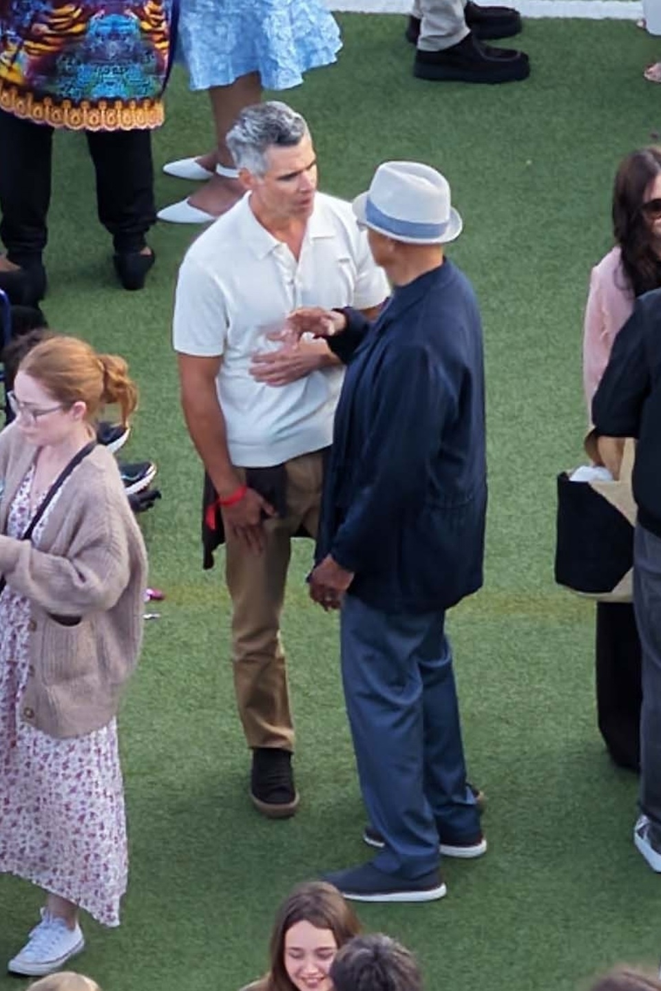Cash Warren speaking to another man at his daughter's graduation.