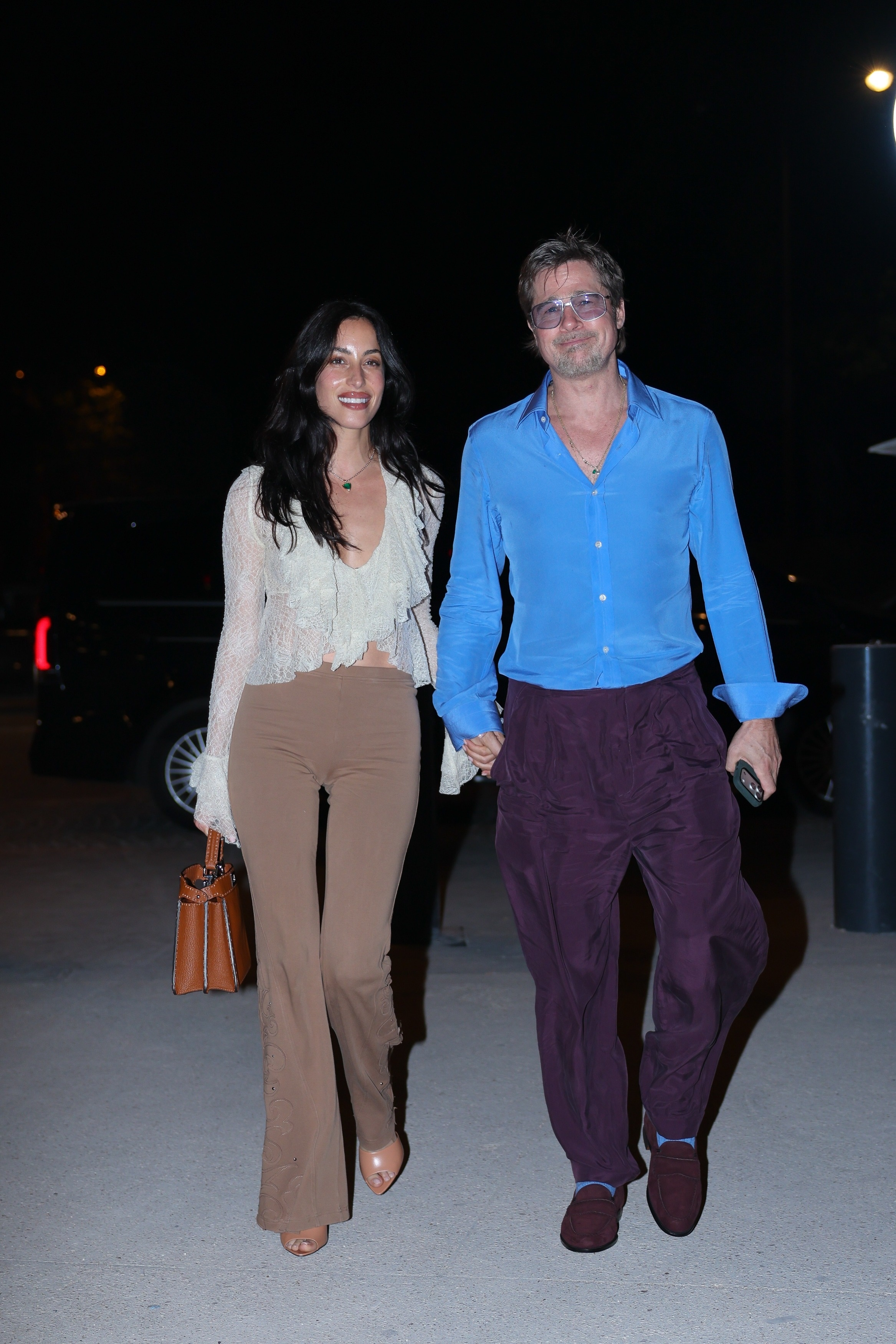 Brad Pitt and Ines de Ramon walking together at night after a Red Hot Chili Peppers concert in Paris.