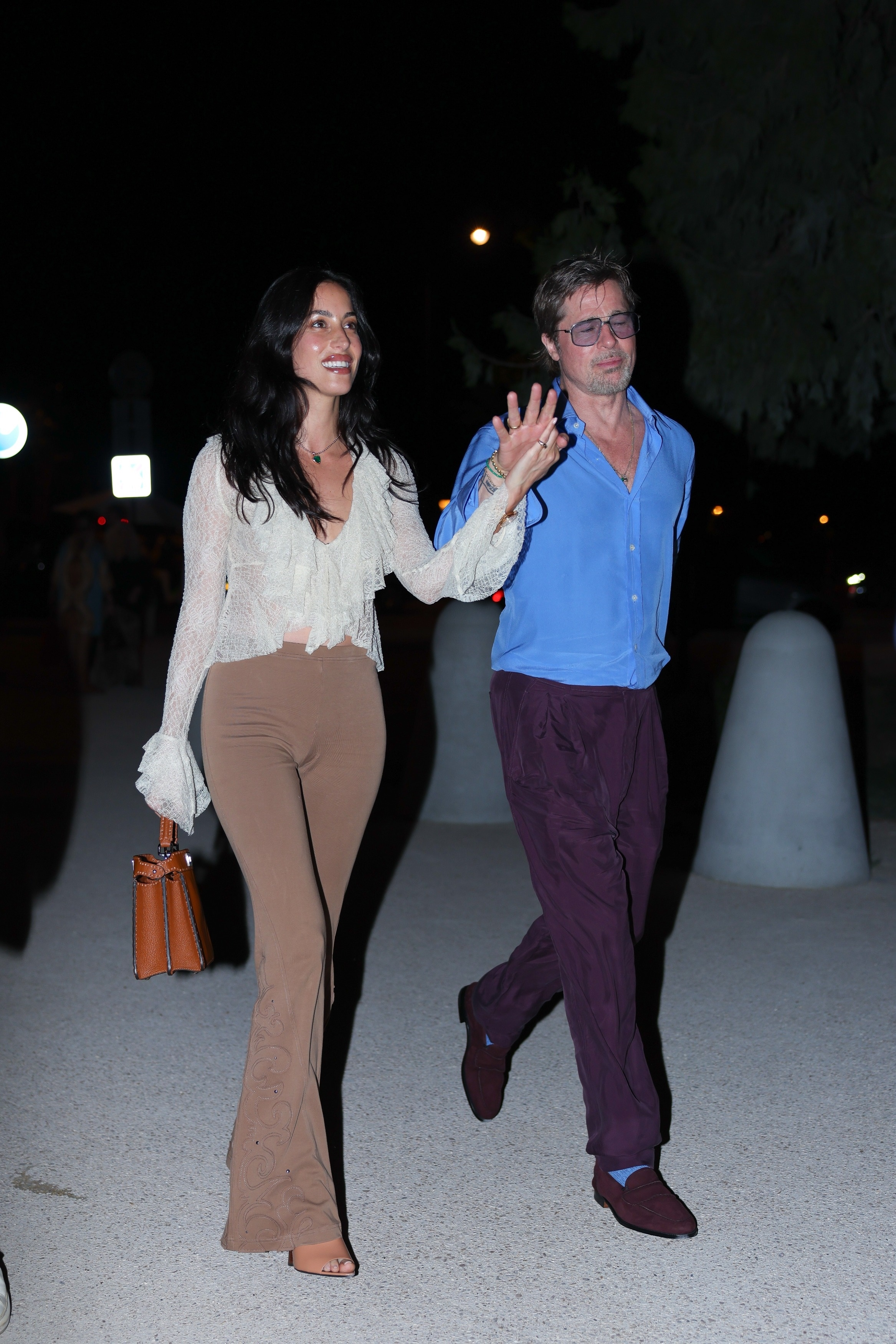 Brad Pitt and Ines de Ramon walking together at night after a Red Hot Chili Peppers concert in Paris.