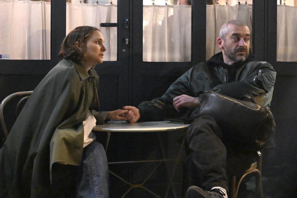 Natalie Portman and Tanguy Destable hold hands while dining al fresco at a restaurant in Paris.