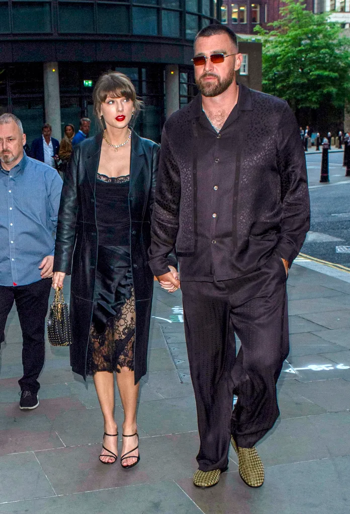 Taylor Swift and Travis Kelce holding hands while walking on a city street.