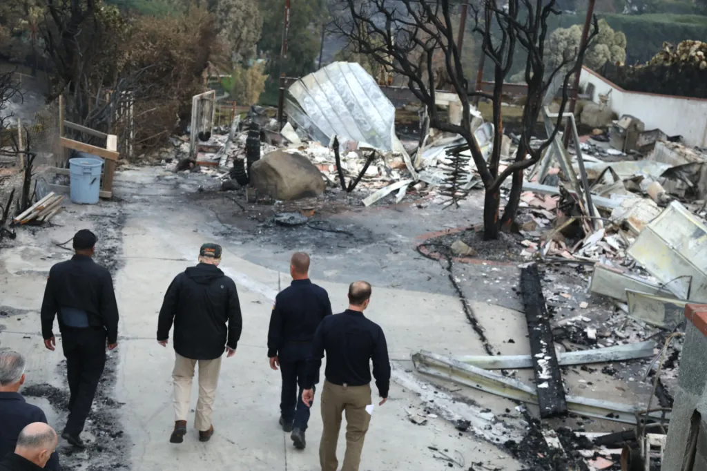 President Trump and first responders walk through a neighborhood destroyed by the Woolsey Fire.