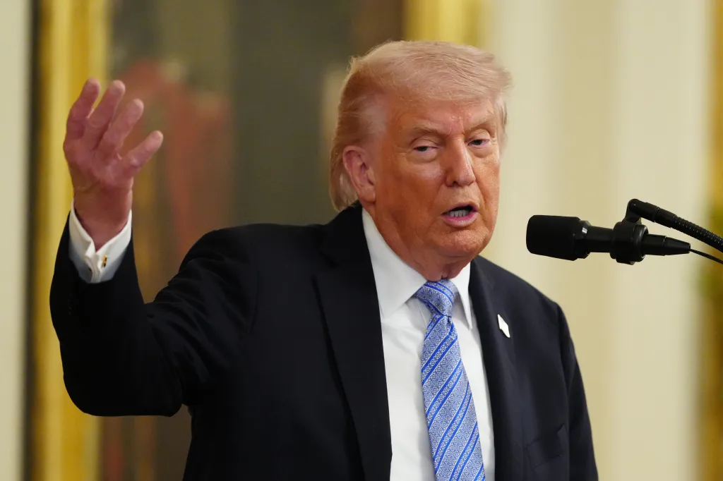 President Donald Trump speaking at an event, gesturing with his left hand.