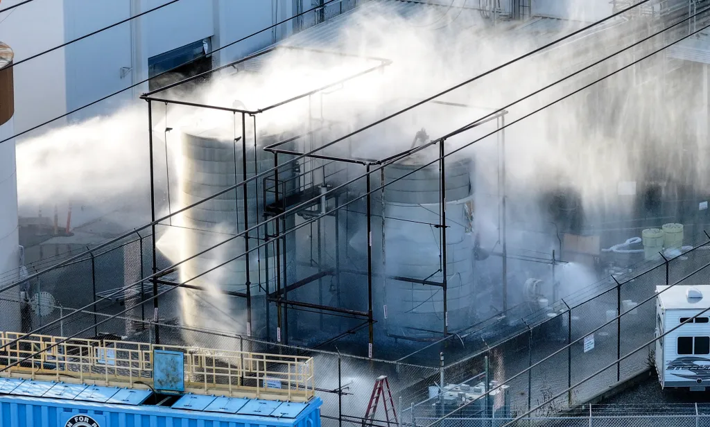Pressurized tanks containing methyl methacrylate being sprayed with water.
