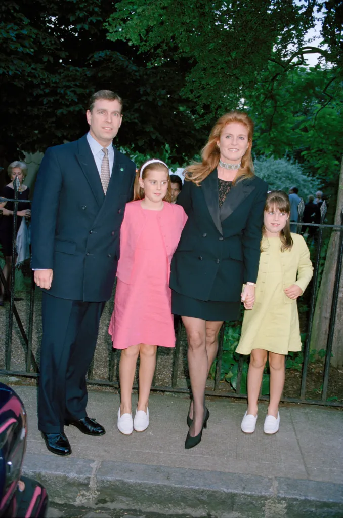 Prince Andrew, Sarah Ferguson, and their daughters Princesses Beatrice and Eugenie, standing together outdoors.