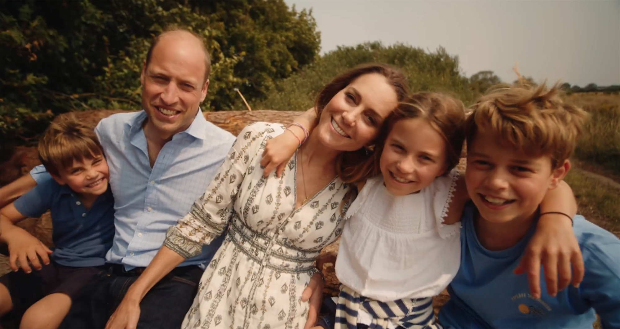 Prince William, Kate Middleton, and their three children smiling together outdoors.