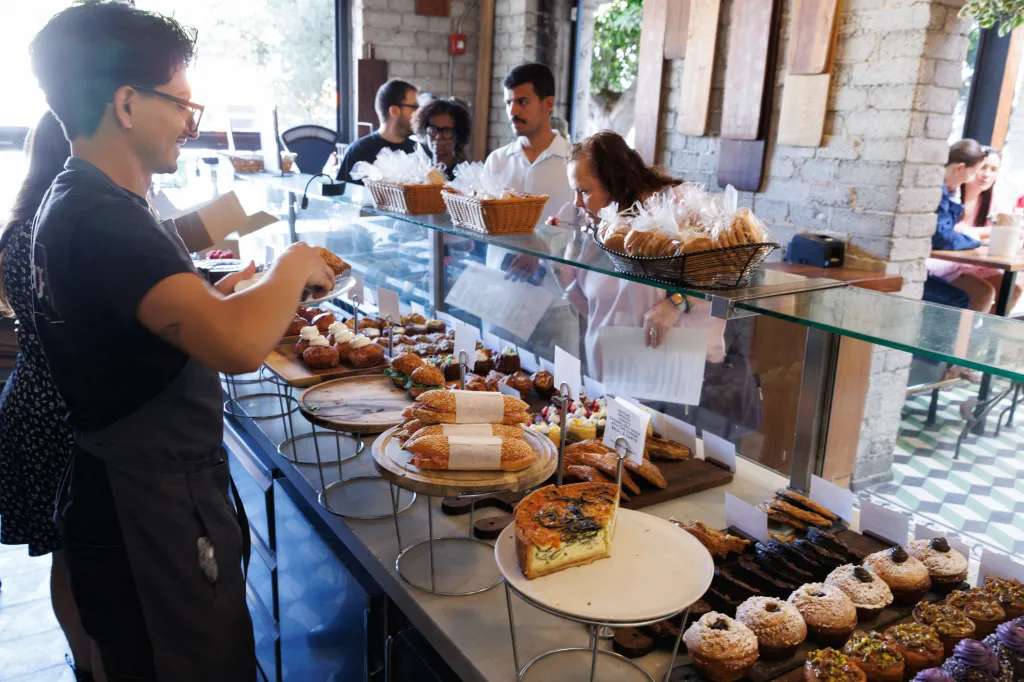 A person wearing an apron serves pastries from a display case at République, a French-inspired bakery in Los Angeles.