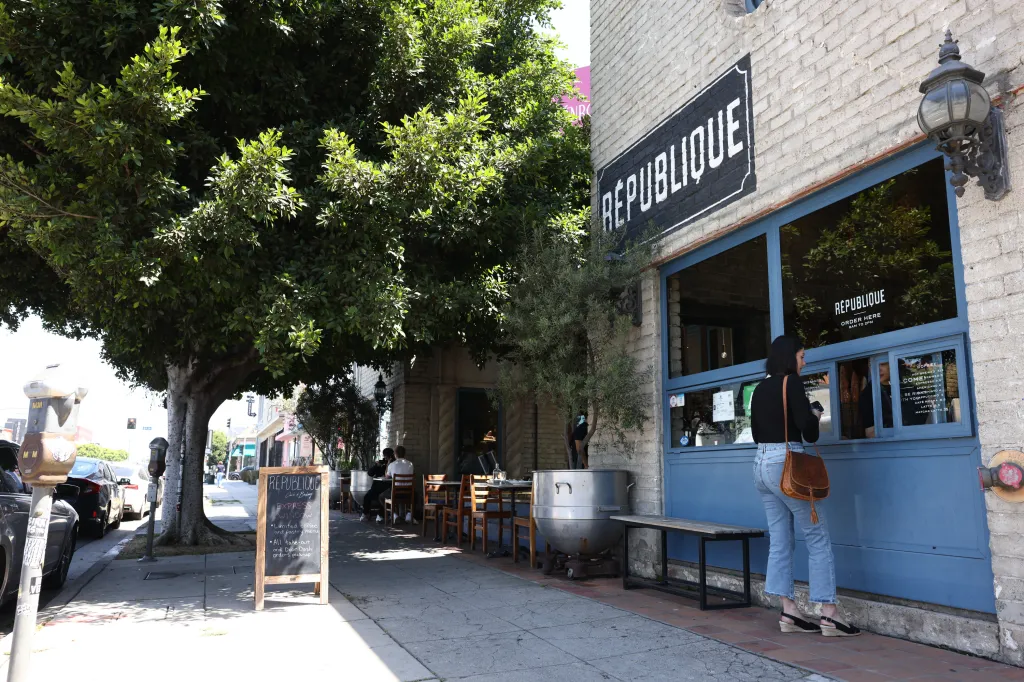 A woman ordering at the takeout window of République, a French-inspired bakery in Los Angeles.