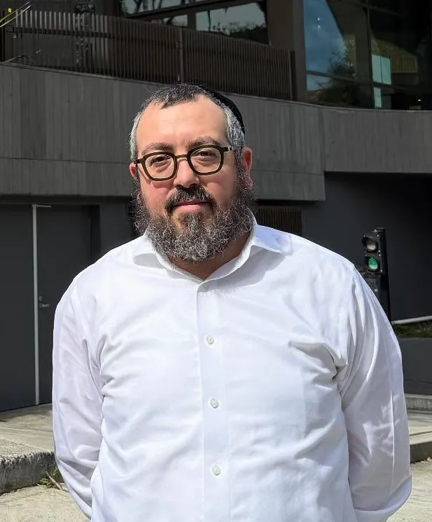 Rabbi Eli Schlanger in a white shirt and glasses.