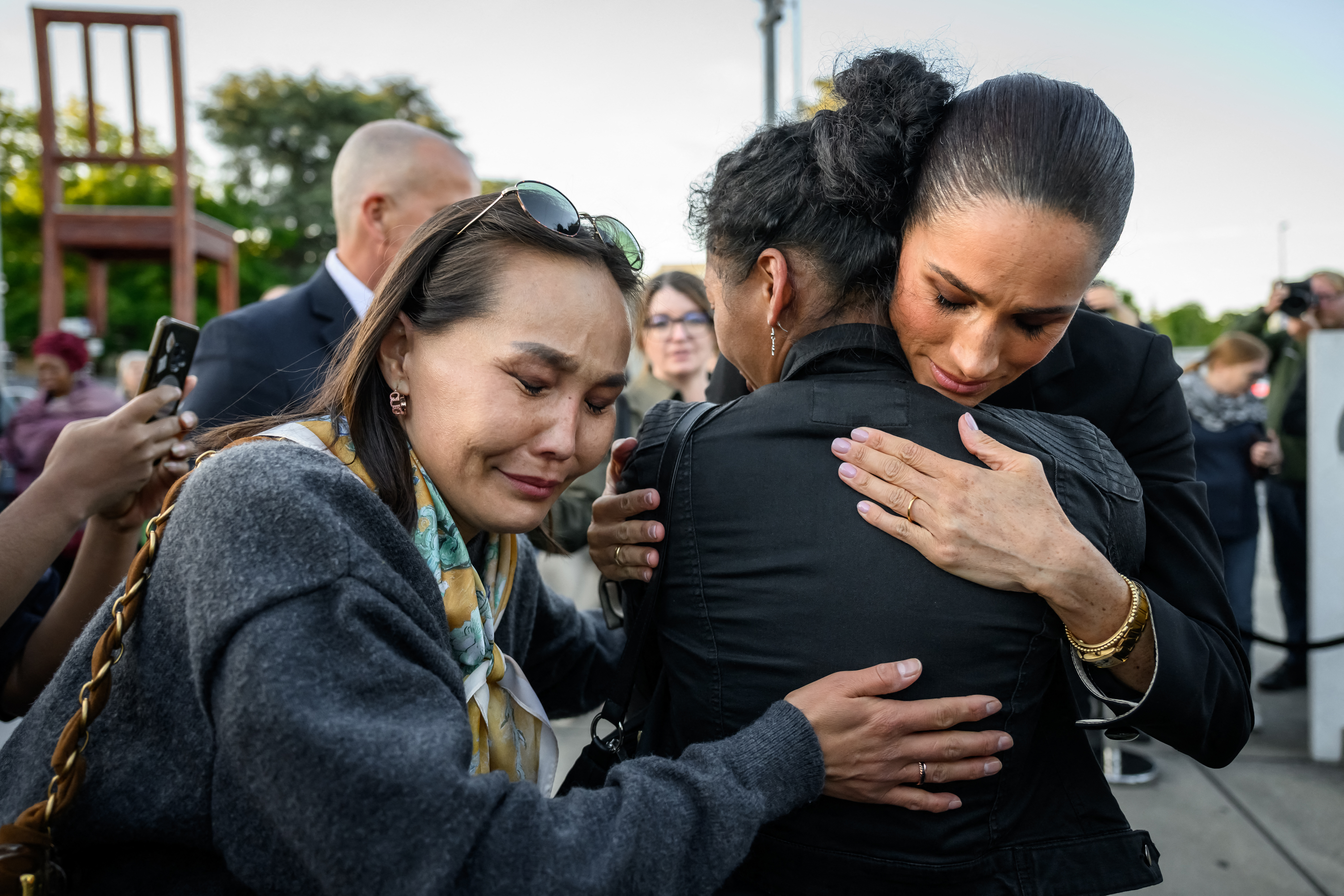 Meghan Markle embraces a crying woman.