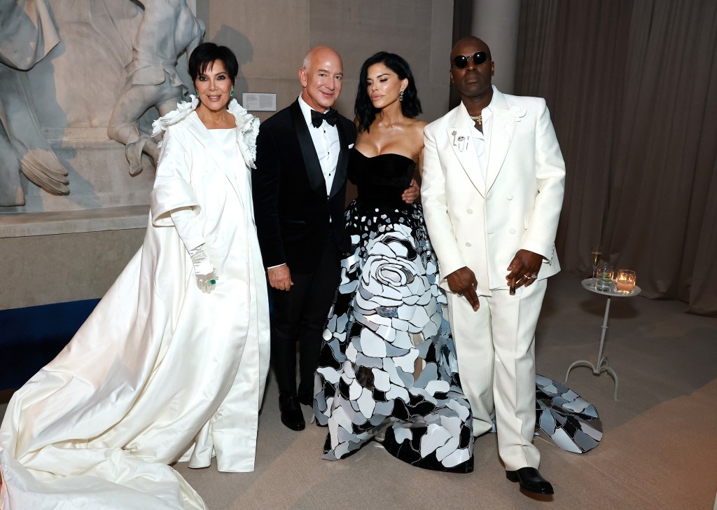 Kris Jenner, in a white gown and white cloak. Jeff Bezos, in black tie, Lauren Sánchez, in a gown with black Bodie and grey and silver patterned skirt, and Corey Gamble, in a white suit, posing at The 2024 Met Gala.