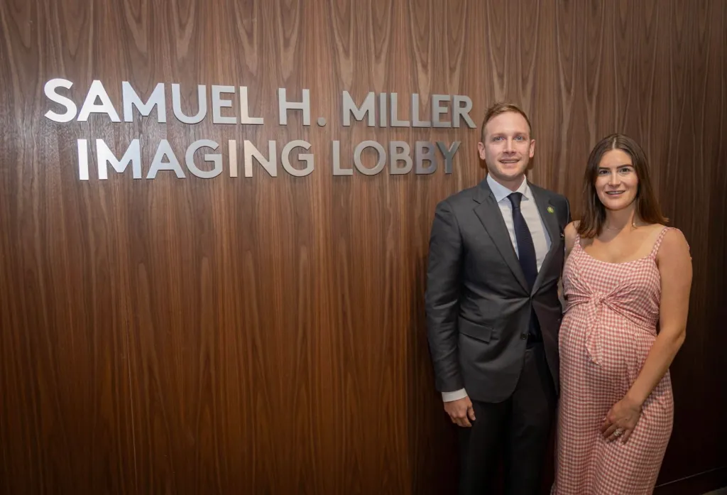 Max Miller and Emily Moreno stand in front of a 