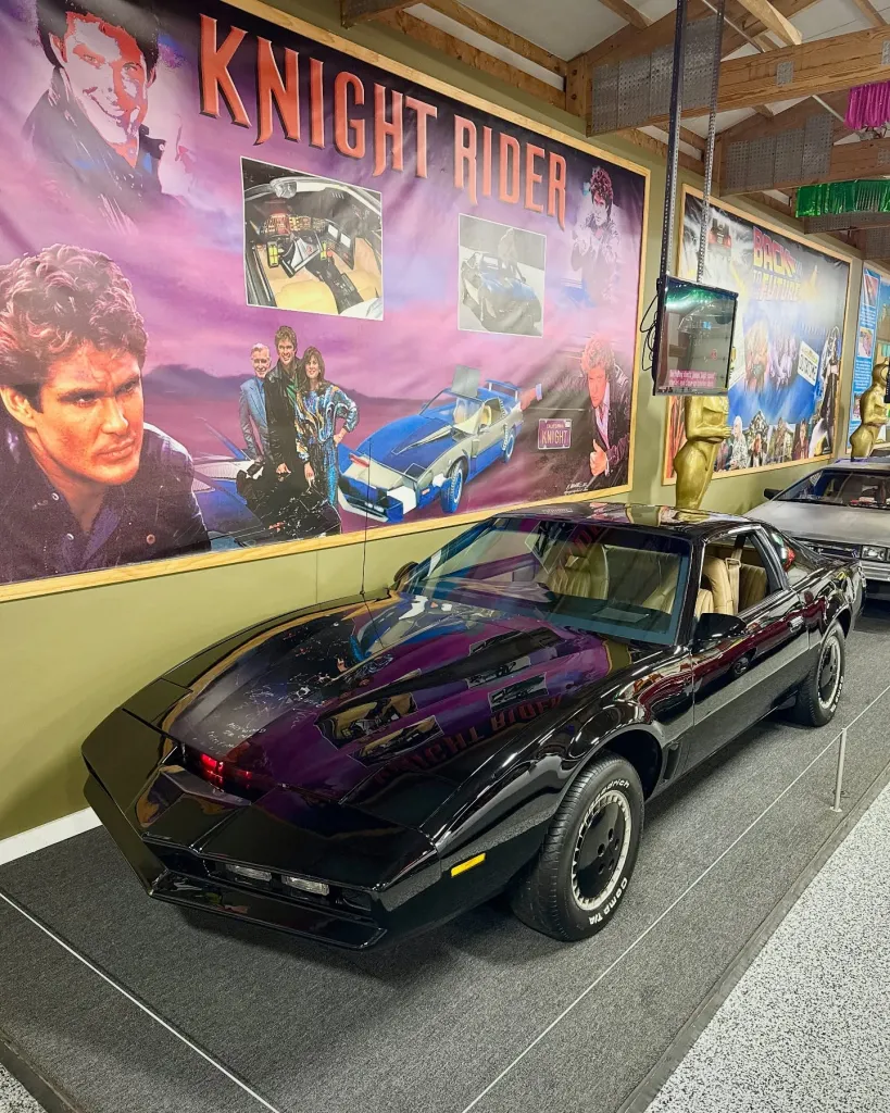 Replica Knight Rider car on display with movie poster backdrop.