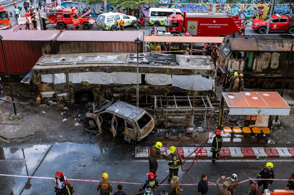 Overhead view of rescue teams and firefighters at the scene of a train-bus collision in Bangkok, Thailand.